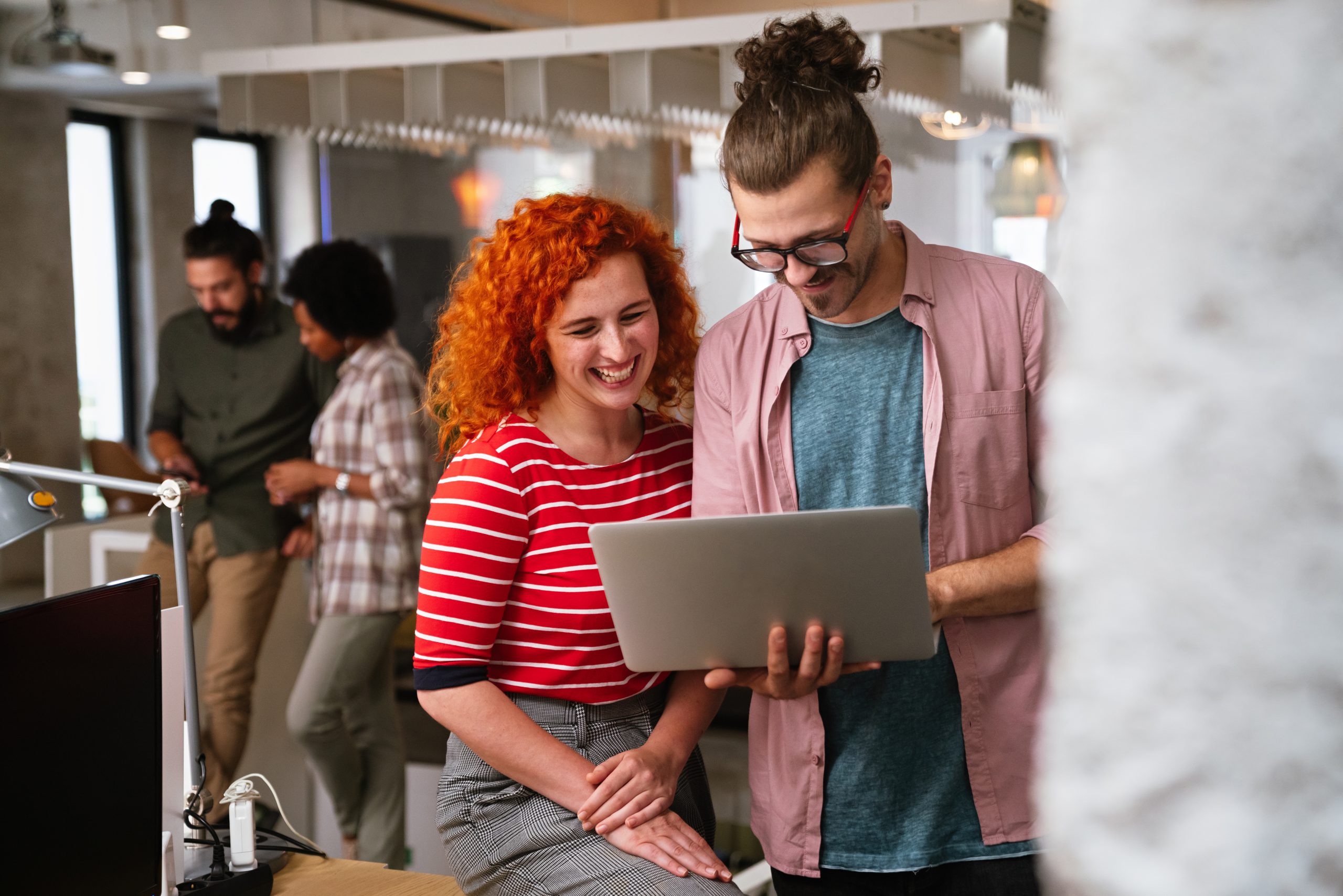 Un groupe diversifié de professionnels se réunissant dans un bureau. Des programmeurs informatiques utilisent un ordinateur et discutent de la stratégie.