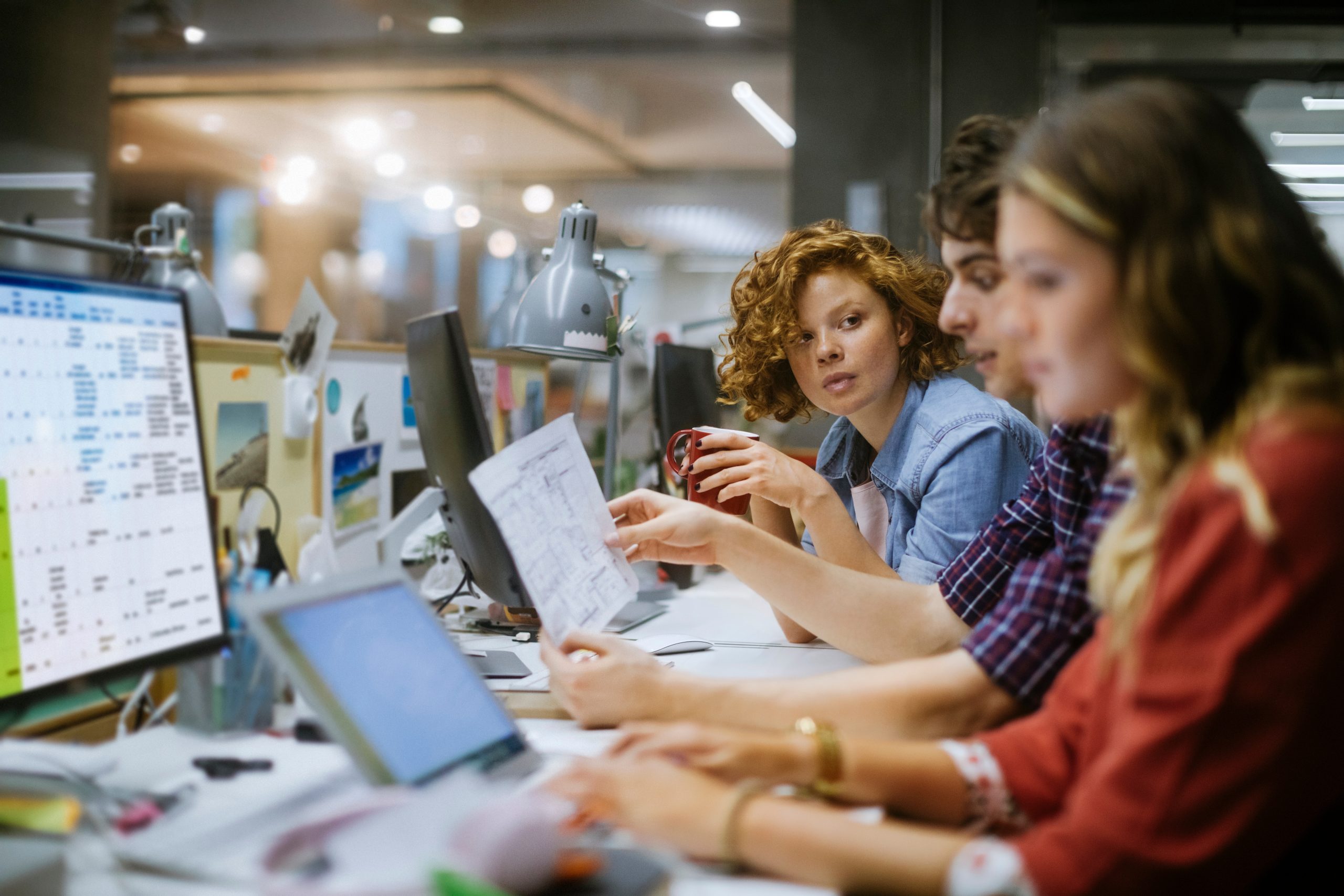 Un groupe diversifié de jeunes employés travaillant ensemble dans un bureau d'affaires moderne.